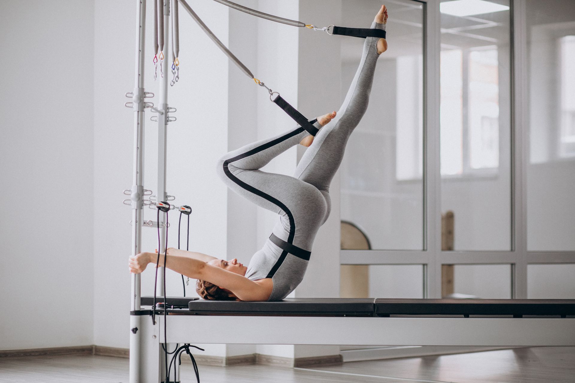 woman-practising-pilates-pilates-reformer-96e59641
