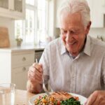 Senhor de idade comendo prato com alimentos saudáveis para evitar sarcopenia