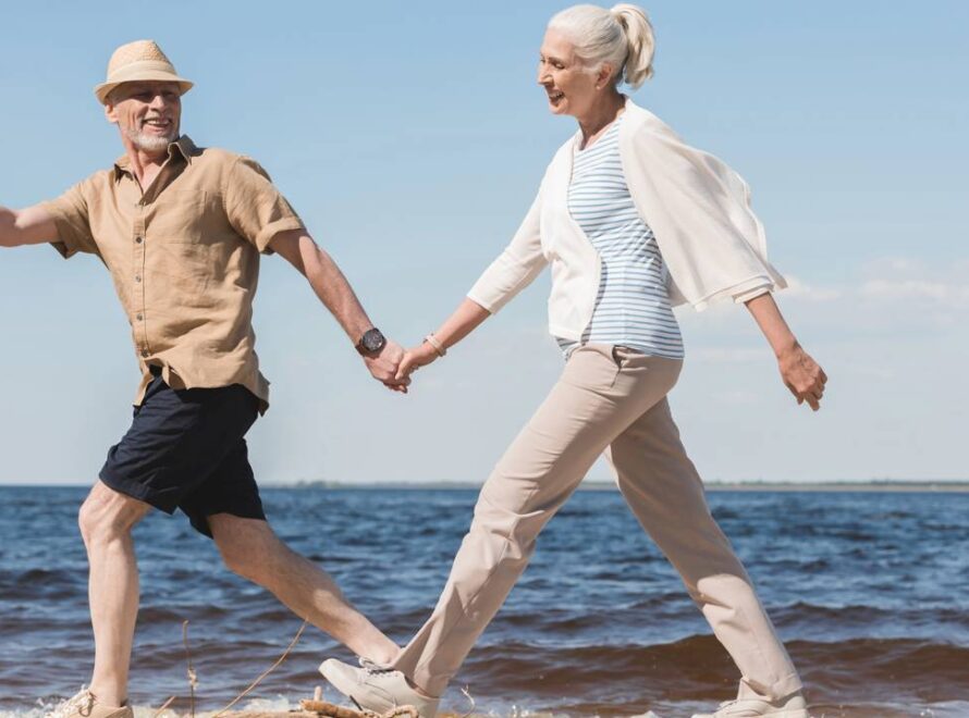 Casal caminhando tranquilo e despreocupado perto da praia