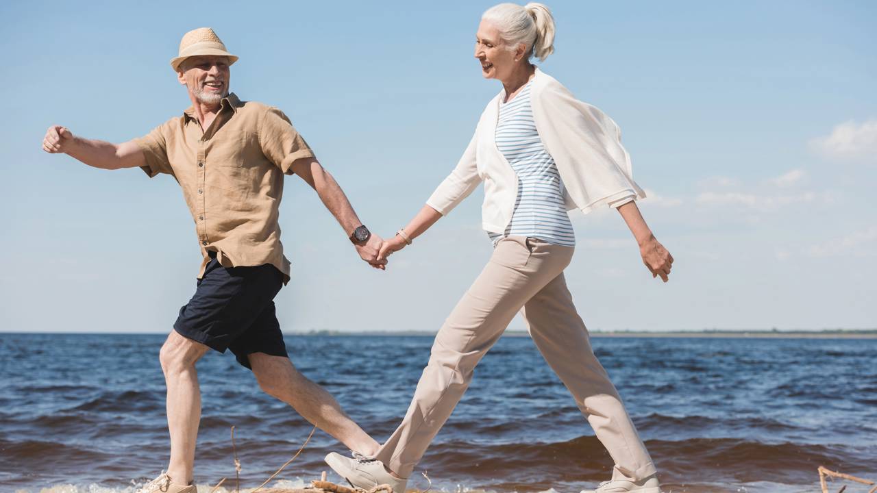 Casal caminhando tranquilo e despreocupado perto da praia