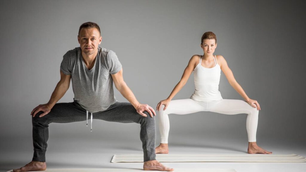 Casal praticando yoga para implementar seu equilíbrio