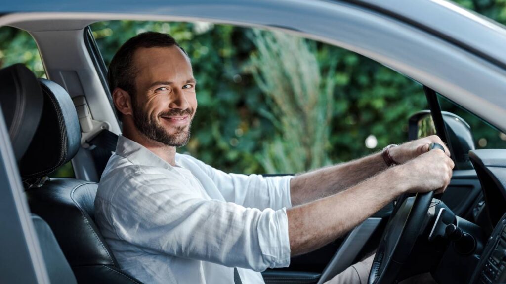 Homem em posse do volante de carro