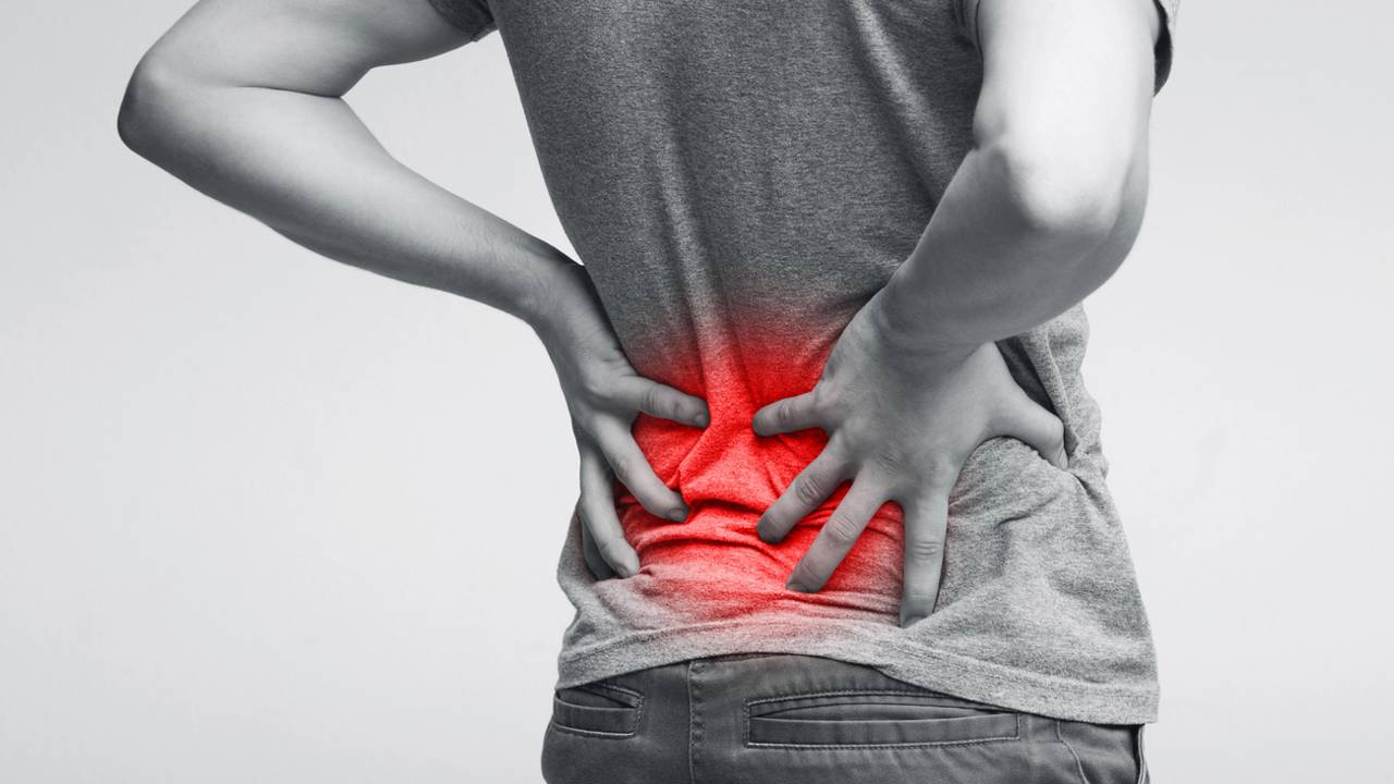 Homem segurando as costas enquanto sofre com dor lombar