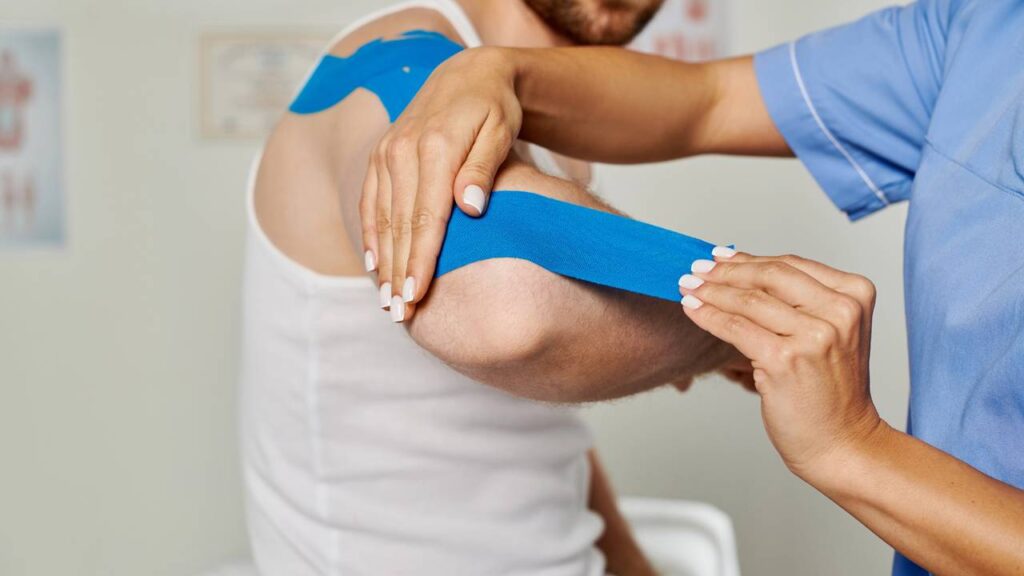 Homem tratando epicondilite em clínica de fisioterapia