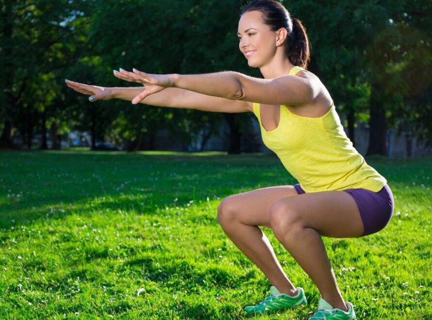 Mulher agachando em atividade física ao ar livre