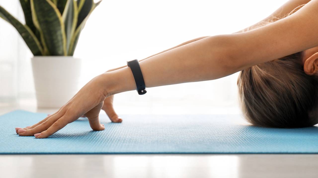 Mulher realizando alongamentos em casa