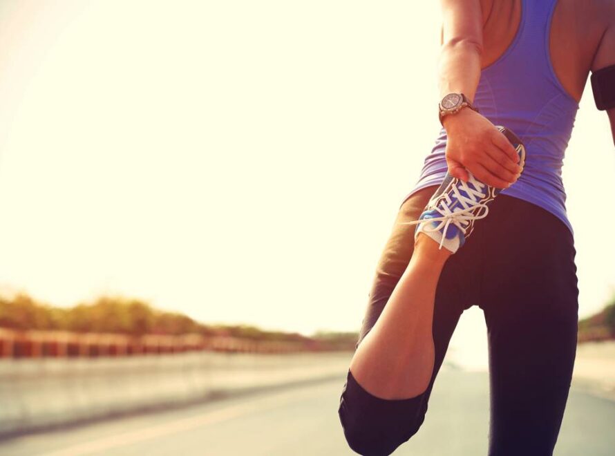 Mulher se alongando para exercício de corrida