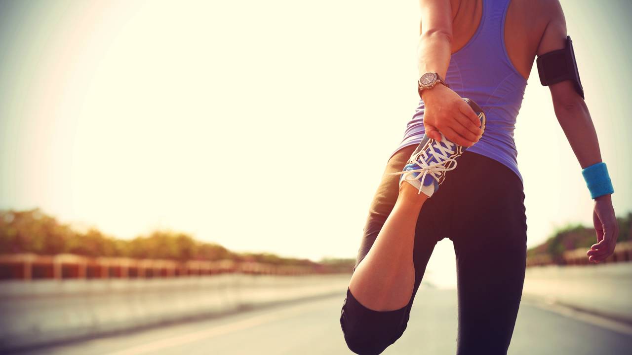 Mulher se alongando para exercício de corrida
