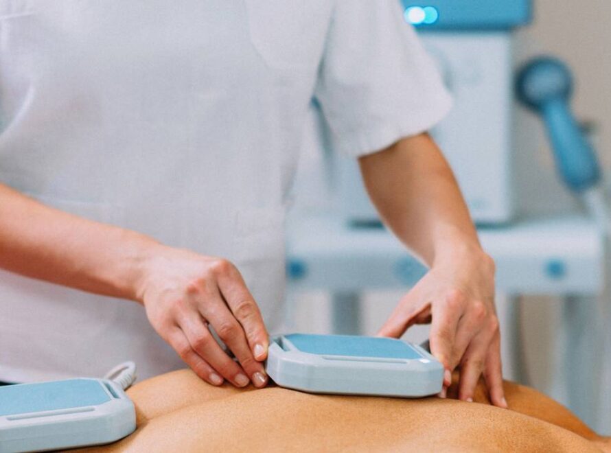 Profissional da área de fisioterapia posicionando ímãs para magnetoterapia