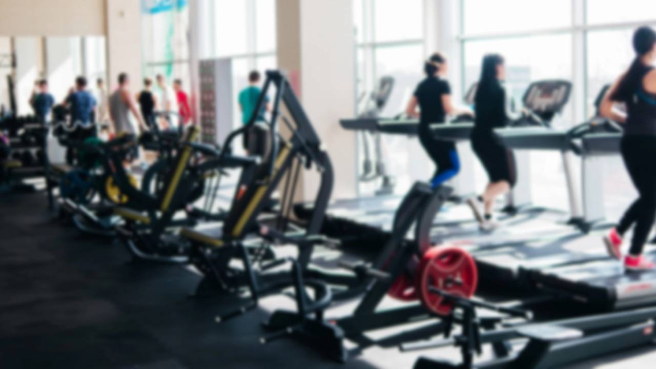 Pessoas na academia usando esteira para correr