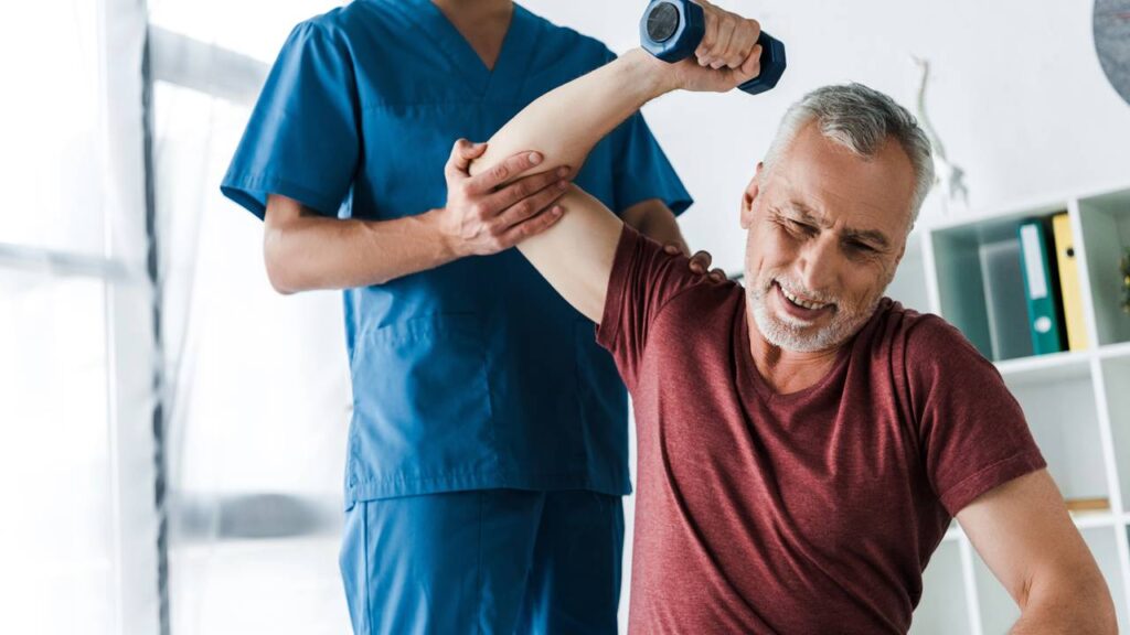 Idoso fazendo treino de força clínico sob supervisão de profissional fisioterapeuta