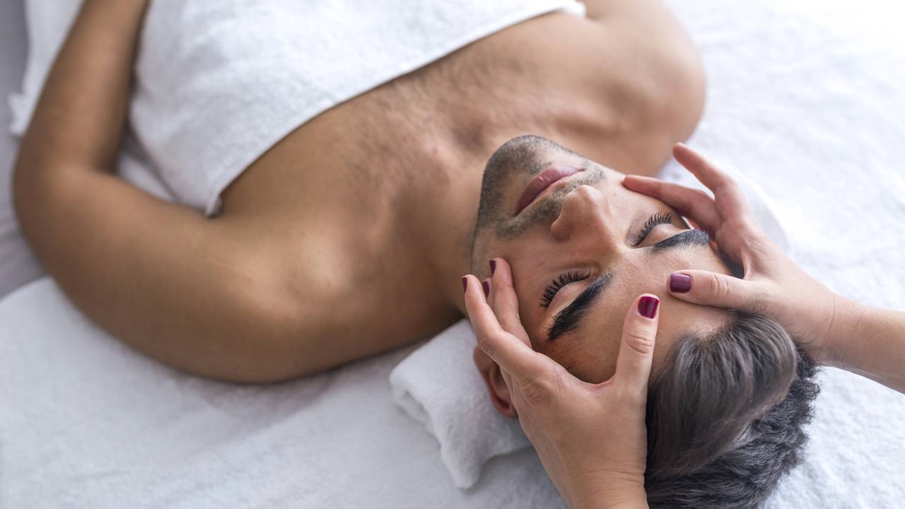 Homem recebendo massagem na região da cabeça