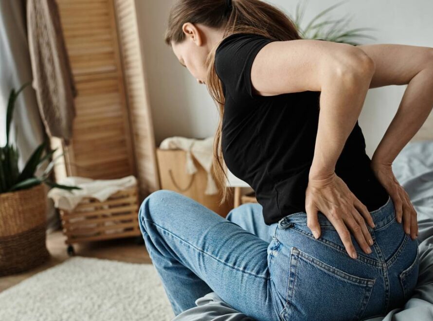 Mulher com dores na coluna por má postura recorrente