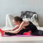 Mulher fazendo alongamento em casa