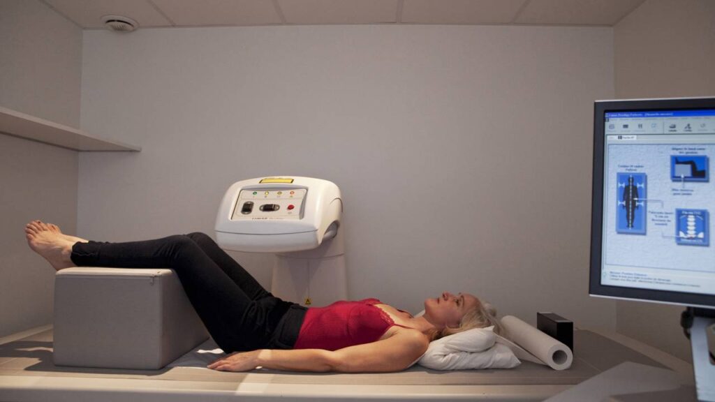 Mulher passando por exame de densidade ossea