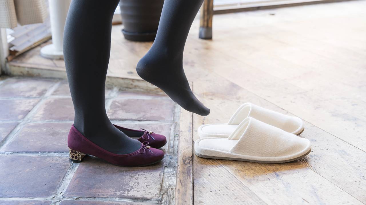 Mulher tirando calçados e calçando outro